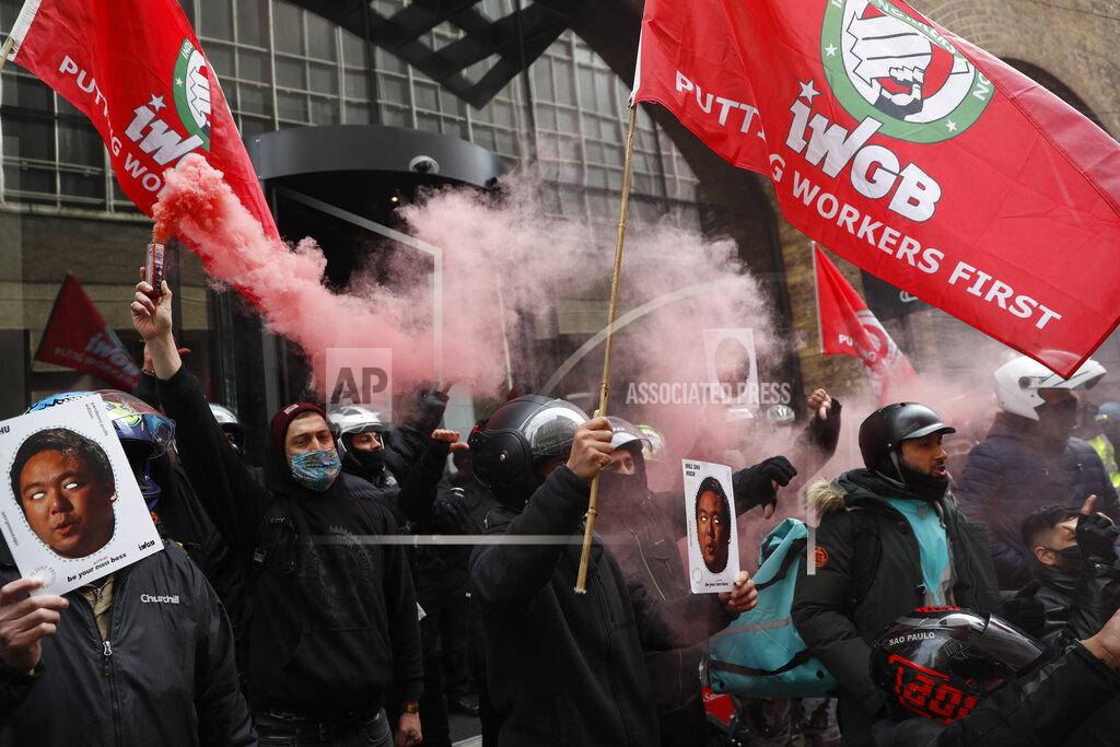 Alastair Grant Gig economy riders for app-based meal delivery platform Deliveroo demonstrate outside the companies headquarters in London, Wednesday, April 7, 2021. The strike coincides with the first day of unconditional trading for Deliveroo shares, which went public last week in a stock market offering. (AP Photo/Alastair Grant)