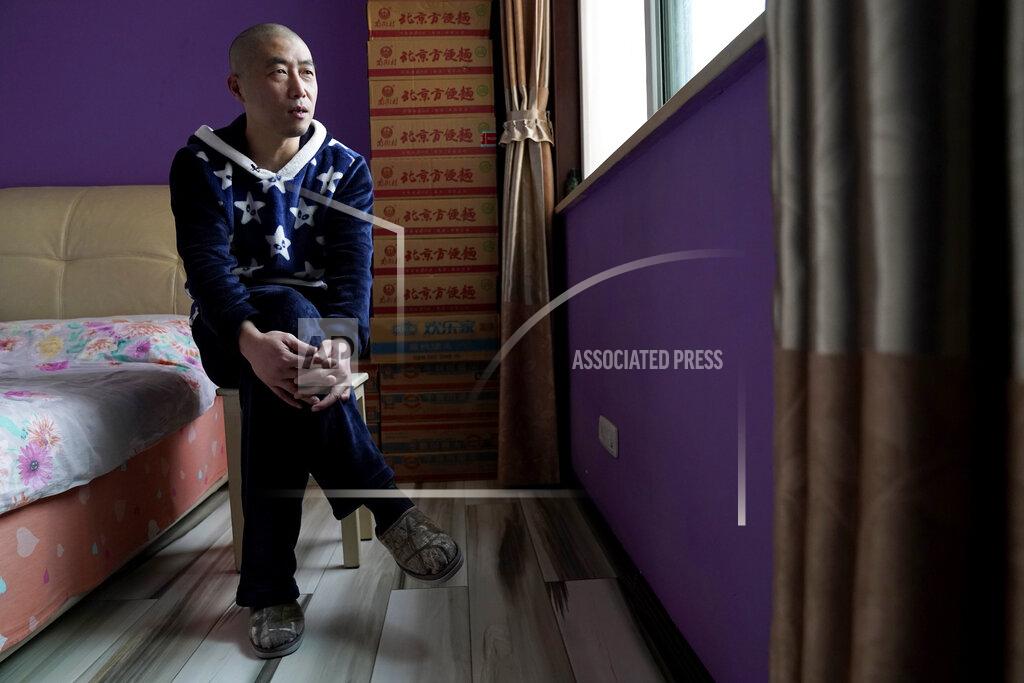 Ng Han Guan Wuhan resident Zhu Tao speaks during an interview near boxes of instant noodles stacked in his bedroom at home in Wuhan in central China's Hubei province on Wednesday, Oct. 21, 2020. Zhu, a government critic, took precautions against the virus early and felt vindicated when the outbreak exploded and the city went into lockdown. But now that the situation is back to something close to normal in Wuhan, Zhu finds himself at odds with his neighbors and the government. (AP Photo/Ng Han Guan)