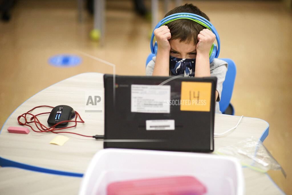 First-grader Kayden Welch gets frustrated with his computer during the first day back to in-person learning at Cliffdale Elementary School in Fayetteville, N.C., on Monday, March 15, 2021. Students last went to school buildings for classes on March 13, 2020. (Andrew Craft /The Fayetteville Observer via AP)