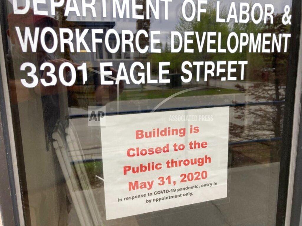 A sign on the door of the state labor department office in Anchorage, Alaska, on Friday, May 22, 2020, shows the office is closed to the public through the end of May. A report released by the department Friday showed the number of jobs in Alaska in April was down sharply compared to April 2019 amid coronavirus concerns. (AP Photo/Mark Thiessen)