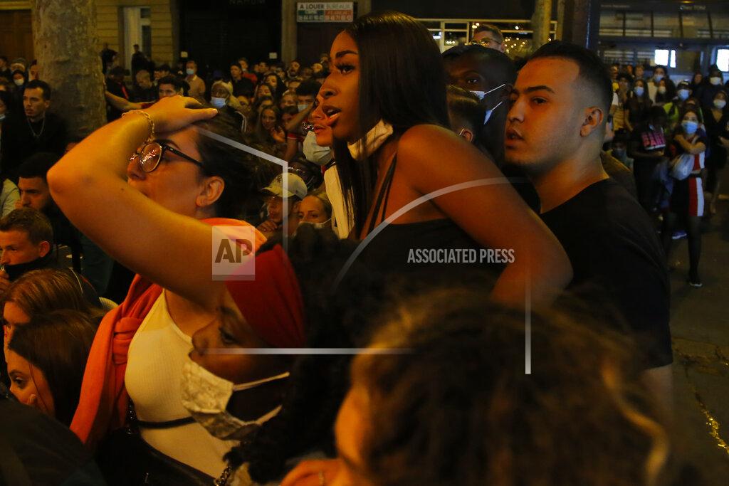 PSG supporters react outside a cafe as they watch the Champions League soccer final match between PSG and Bayern Munich which is played in Lisbon, Portugal, Sunday Aug. 23, 2020 in Paris. (AP Photo/Michel Euler)