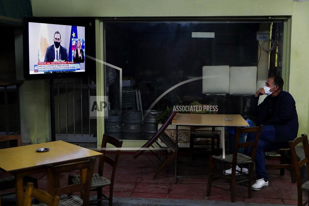 Petros Karadjias A Cypriot man sits at a social club and watch the televised address of Cyprus' Health Minister Constantinos Ioannou explaining the need for additional restrictions to beat back a surge in COVID-19 cases in Nicosia suburb of Lakatamia, Cyprus, on Tuesday, Nov. 11, 2020. Cyprus has put its entire southwest under a strict 19-day lockdown, banning any non-essential movement of people and shuttering bars and restaurants after a string of escalating restrictions failed to curb a sharp increase in COVID-19 infections. (AP Photo/Petros Karadjias)