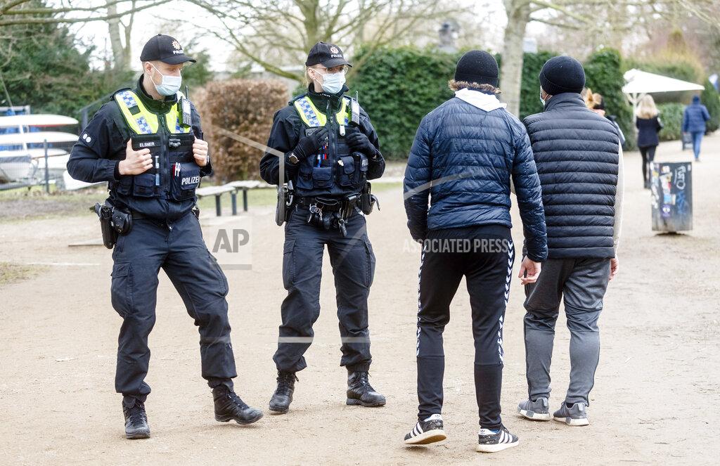 Markus Scholz Police officers address walkers around Hamburg's Outer Alster who do not adhere to the strict mask requirement in Hamburg, Germany, Sunday, Feb.28, 2021. In case of repetition, they can impose a fine. (Markus Scholz/dpa via AP)