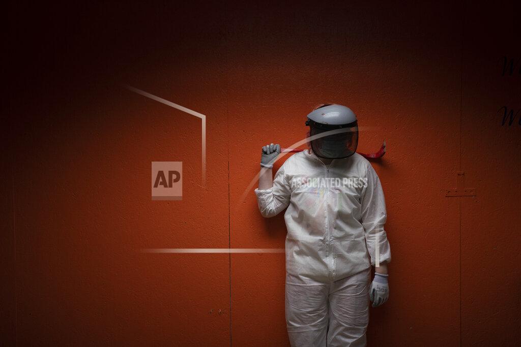 Jae C. Hong Piper Mape, 17, watches her two sisters smash objects while taking a break with a crowbar on her shoulder in a rage room at Smash RX LLC in Westlake Village, Calif., Friday, Feb. 5, 2021. Meditation, yoga, Pilates, they may be fine for some people. But after nearly a year in COVID-19 isolation, some people just want to grab a sledgehammer and smash everything in sight. Thankfully, for them there are now two "rage rooms" located in the Los Angeles suburb of Westlake Village, where they can do just that and not get in trouble. (AP Photo/Jae C. Hong)