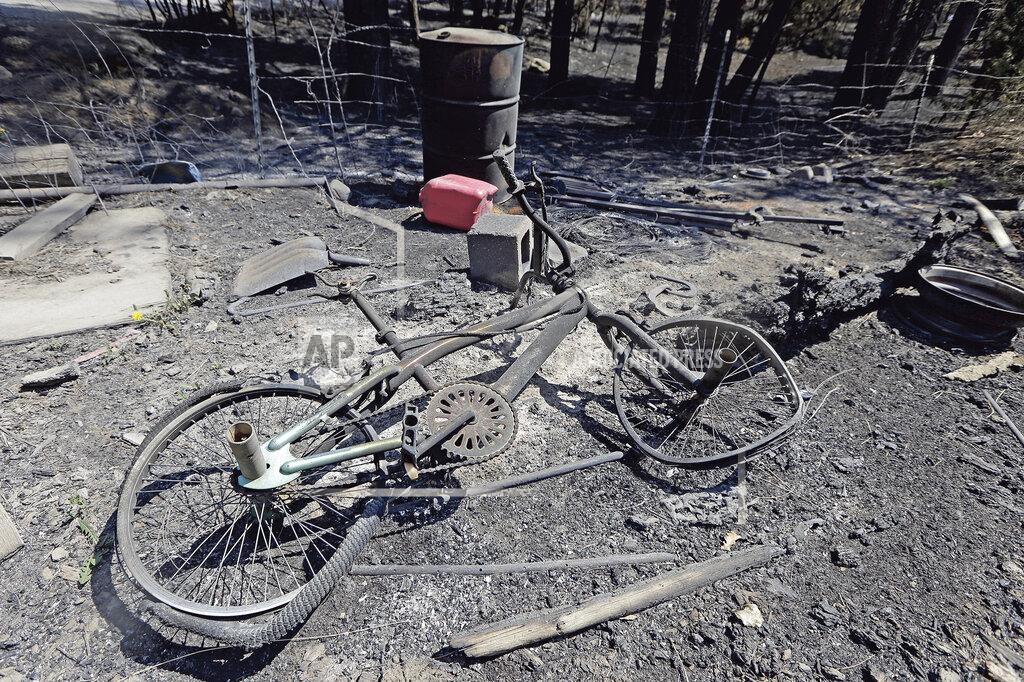 Luis Sanchez Saturno A burnt bicycle is among the remains of a burnt mobile home in the community of San Ignacio following a wildfire near Las Vegas, New Mexico, on Tuesday, May 10, 2022. The largest wildfire burning in the United States was heading toward mountain resort towns in northern New Mexico on Wednesday, prompting officials to issue another set of warnings for more people to prepare to evacuate as the fast-moving fire picks up momentum. (Luis Sanchez Saturno/The New Mexican via AP)
