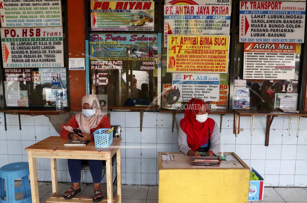 Tatan Syuflana Employees wait for customers at the ticket counters at the Kalideres bus terminal in Jakarta, Indonesia, Wednesday, May 5, 2021. The mass exodus out of major cities in the world's most populous Muslim country is underway despite travel restrictions imposed by the government to prevent the spread of coronavirus outbreak, as people are heading home to their villages to celebrate Eid al-Fitr holiday that marks the end of the holy fasting month of Ramadan on May 13. (AP Photo/Tatan Syuflana)