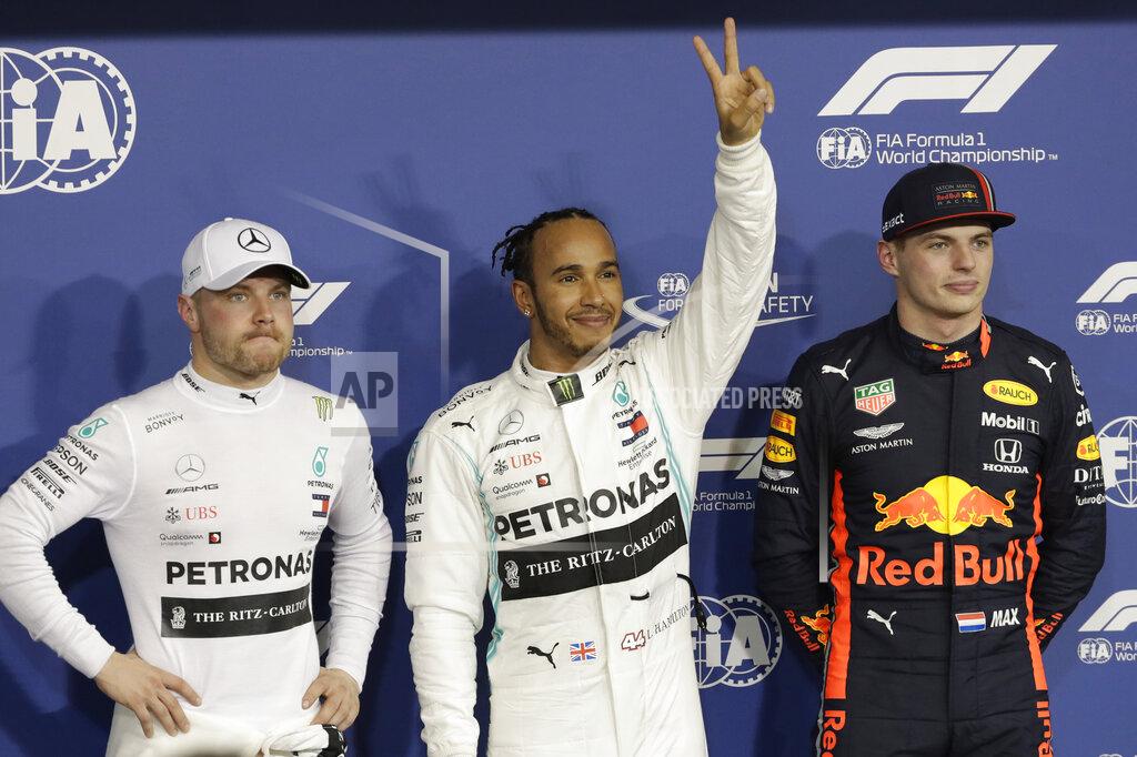 Luca Bruno Mercedes driver Lewis Hamilton of Britain, centre, celebrates his pole position with Mercedes driver Valtteri Bottas of Finland, left, and Red Bull driver Max Verstappen of the Netherland's during the qualifying session at the Yas Marina racetrack in Abu Dhabi, United Arab Emirates, Saturday, Nov. 30, 2019. The Emirates Formula One Grand Prix will take place on Sunday. (AP Photo/Luca Bruno)