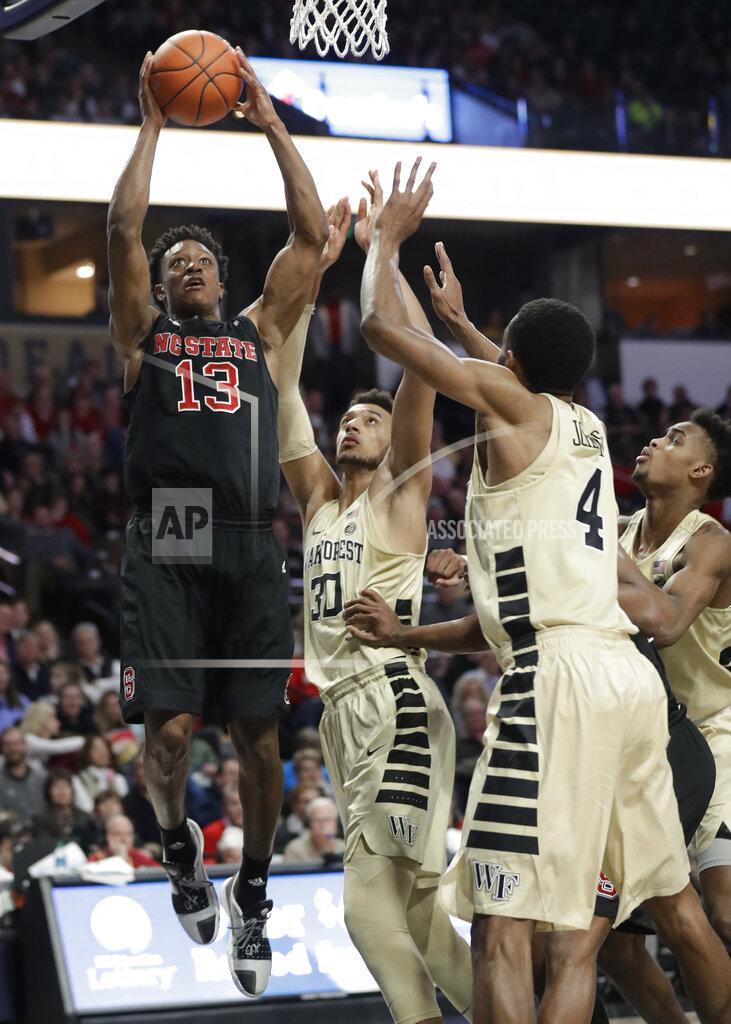 Chuck Burton North Carolina State's C.J. Bryce (13) drives against Wake Forest's Torry Johnson (4) and Olivier Sarr (30) during the second half of an NCAA college basketball game in Winston-Salem, N.C., Tuesday, Jan. 15, 2019. (AP Photo/Chuck Burton)