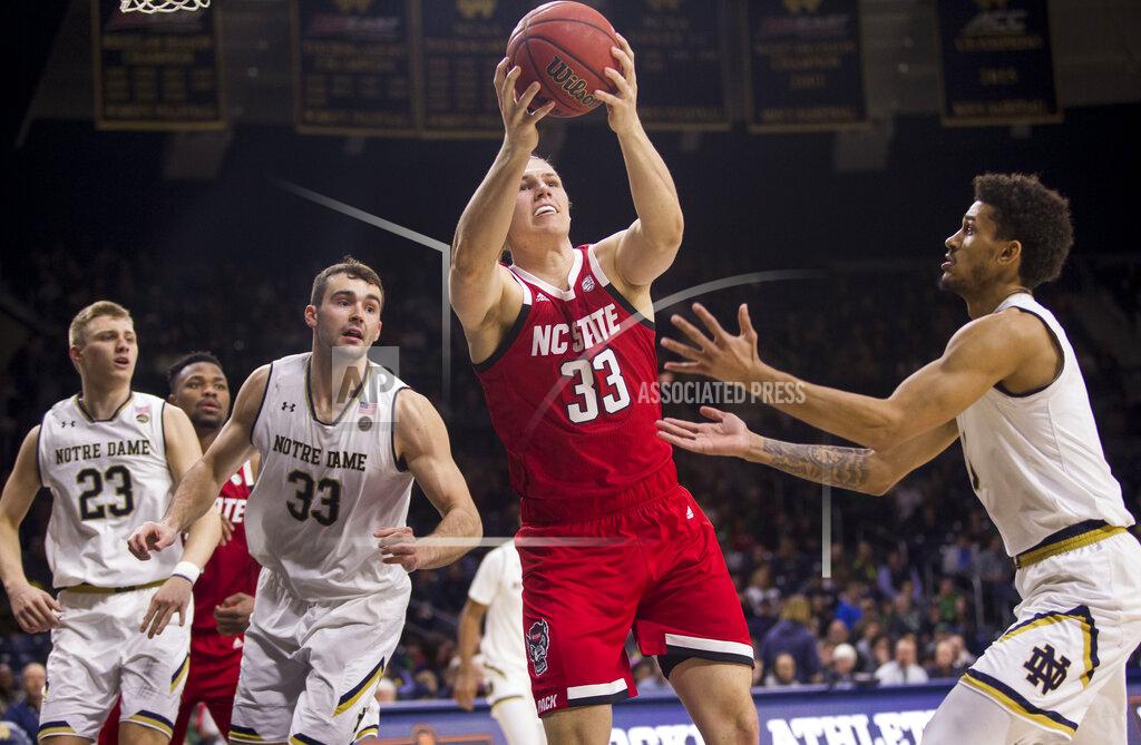 Robert Franklin North Carolina State's Wyatt Walker (33) grabs a rebound between Notre Dame's Dane Goodwin (23), John Mooney (33) and Prentiss Hubb during the second half of an NCAA college basketball game Saturday, Jan. 19, 2019, in South Bend, Ind. North Carolina State won 77-73. (AP Photo/Robert Franklin)