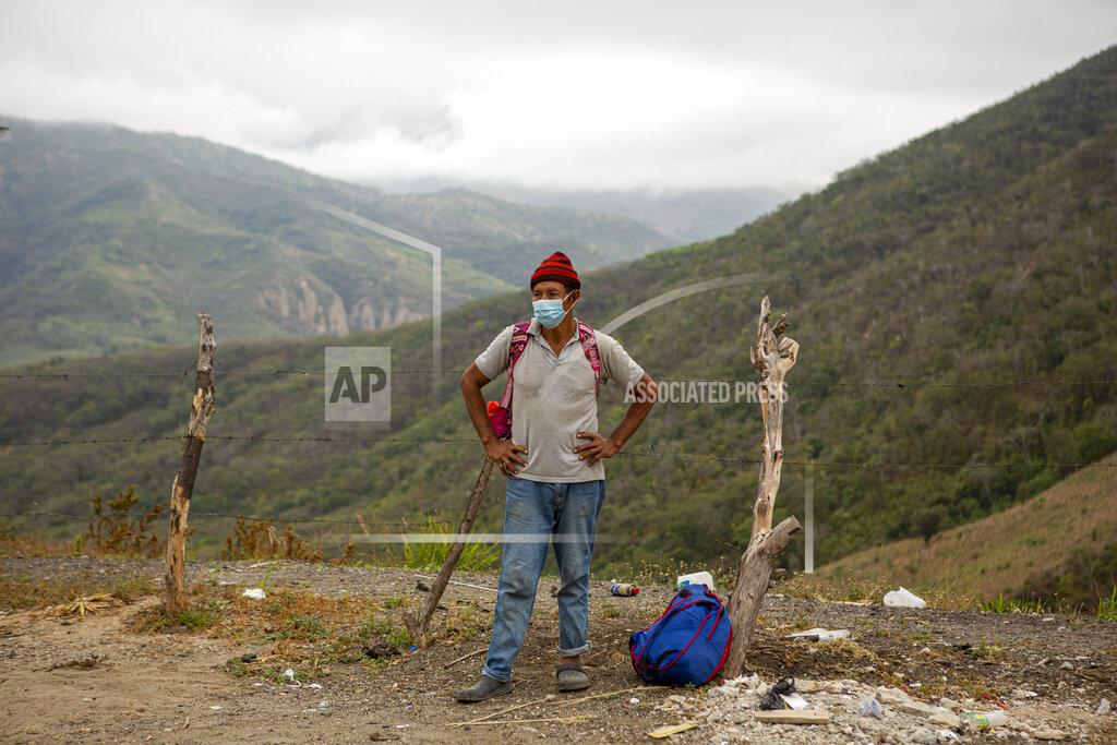 Oliver De Ros A Honduran migrant waits at a police checkpoint after being detained by police in Zacapa, Guatemala, Tuesday, Jan. 19, 2021. A once large caravan of Honduran migrants that pushed its way into Guatemala last week had dissipated by Tuesday in the face of Guatemalan security forces. (AP Photo/Oliver de Ros)