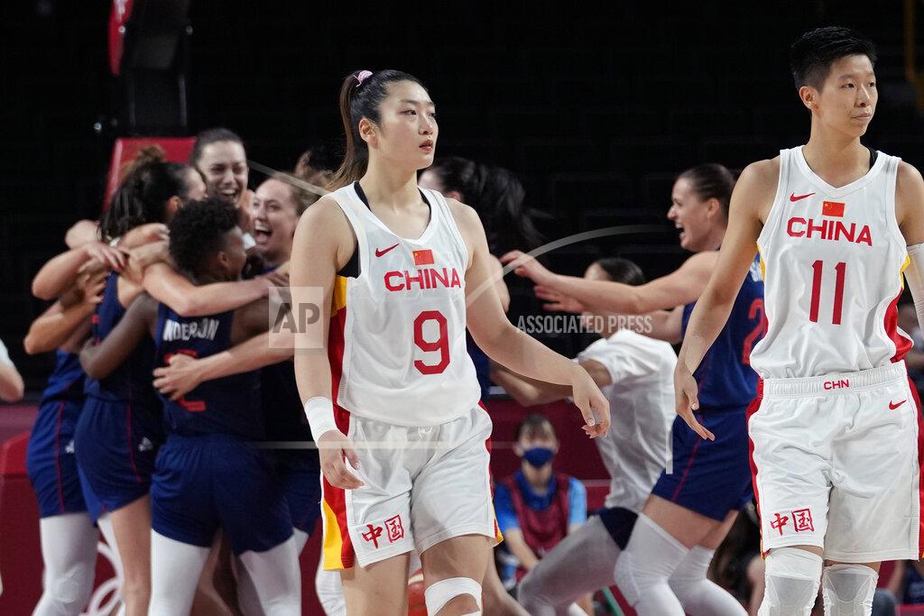 Eric Gay China's Meng Li (9) and Sijing Huang (11) walk off the court as Serbia celebrates their win following a women's basketball quarterfinal game at the 2020 Summer Olympics, Wednesday, Aug. 4, 2021, in Saitama, Japan. (AP Photo/Eric Gay)