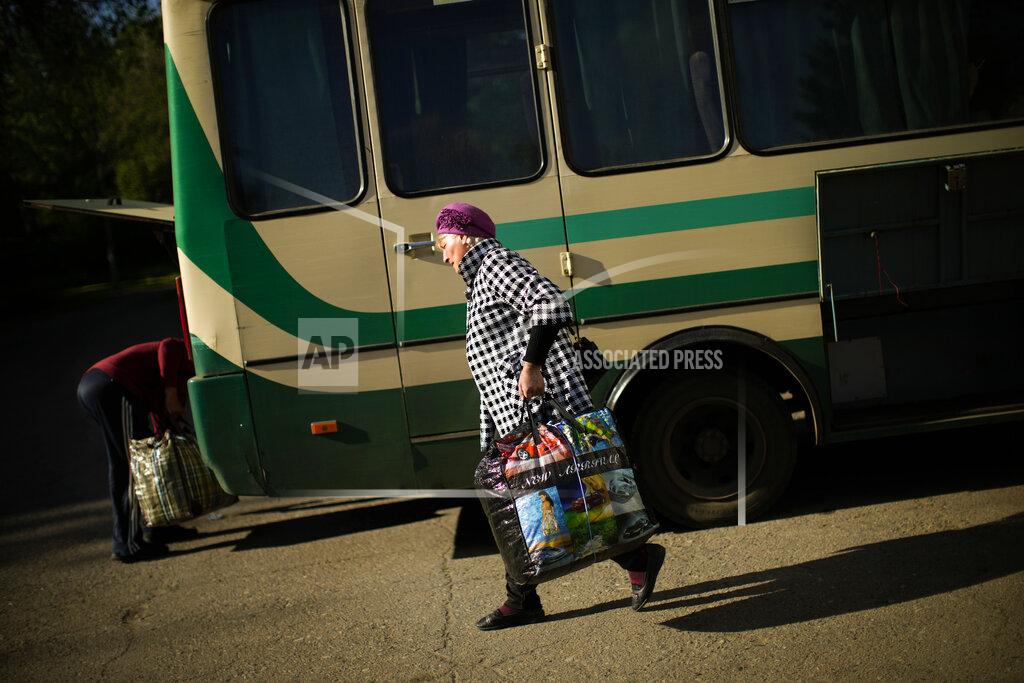 Francisco Seco A woman, fleeing from an area near the front line in Donetsk, carries her belongings as she boards a bus in Kurakhove, eastern Ukraine, Monday, May 23, 2022. In the Donbas region, people continue to flee from towns and villages coming under heavy bombardment. (AP Photo/Francisco Seco)