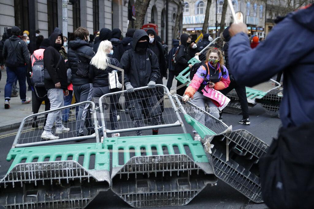 Matt Dunham Demonstrators drag road works fences into the street during clashes with police following a 'Kill the Bill' protest in London, Saturday, April 3, 2021. The demonstration is against the contentious Police, Crime, Sentencing and Courts Bill, which is currently going through Parliament and would give police stronger powers to restrict protests. (AP Photo/Matt Dunham)
