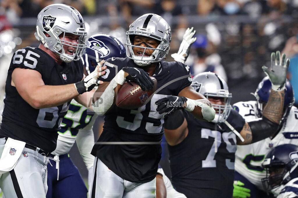 Steve Marcus CORRECTS TO B.J. EMMONS, INSTEAD OF THEO RIDDICK - Las Vegas Raiders center Jimmy Morrissey (65) celebrates after B.J. Emmons, center, scored a touchdown against the Seattle Seahawks during the second half of an NFL preseason football game, Saturday, Aug. 14, 2021, in Las Vegas. (AP Photo/Steve Marcus)