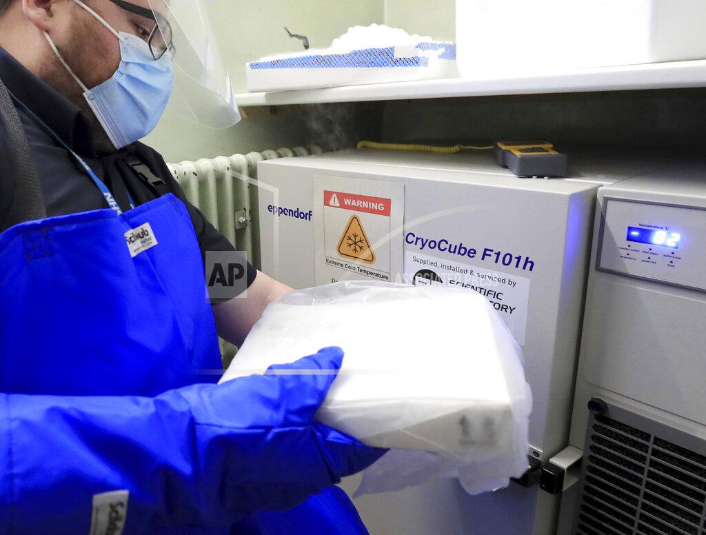 Gareth Fuller A pharmacy technician from Croydon Health Services prepares to store the first delivery of COVID-19 vaccine, with temperature at right reading minus 82, at Croydon University Hospital in Croydon, England, Saturday Dec. 5, 2020. The Croydon University Hospital has taken delivery of the first batch of Pfizer COVID-19 vaccine in preparation or a public inoculation program, with each person needing two injections and the vaccine stored at extremely low temperature.(Gareth Fuller/Pool via AP)