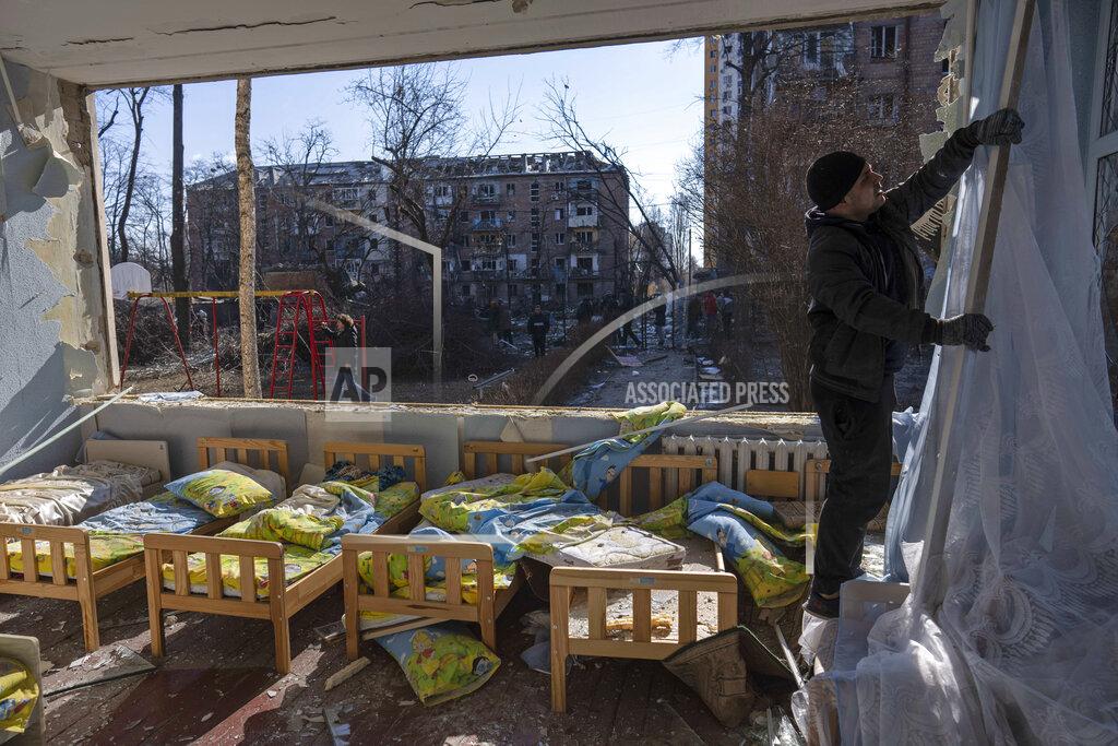 Rodrigo Abd FILE - A man removes a destroyed curtain inside a school damaged among other residential buildings in Kyiv, Ukraine, Friday, March 18, 2022. As of early May, the Ukrainian government says Russia has shelled more than 1,000 schools, completely destroying 95. (AP Photo/Rodrigo Abd, File)