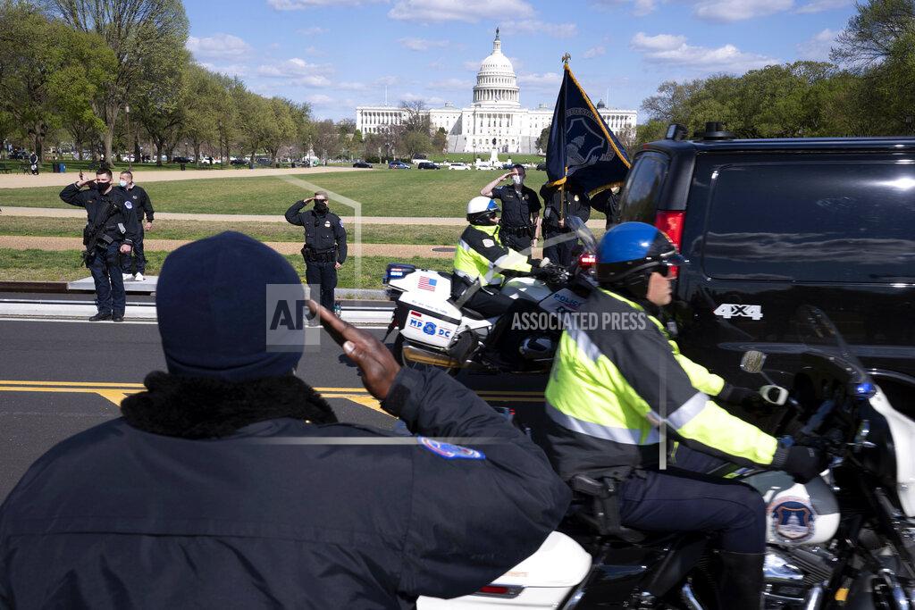 Jose Luis Magana With the U.S. Capitol in the background, U.S. Capitol Police officers salute as procession carries the remains of a U.S. Capitol Police officer who was killed after a man rammed a car into two officers at a barricade outside the Capitol in Washington, Friday, April 2, 2021. (AP Photo/Jose Luis Magana)