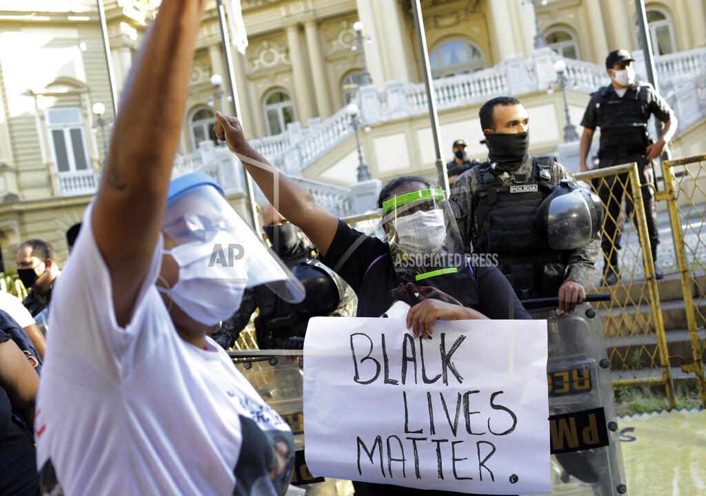 Silvia Izquierdo Women wearing face shields against the spread of the new coronavirus, protest against crimes committed by the police against black people in the favelas, outside the Rio de Janeiro's state government, Brazil, Sunday, May 31, 2020. The protest, called "Black lives matter," was interrupted when police used tear gas to disperse people. "I can't breathe", said some of the demonstrators, alluding to the George Floyd's death. (AP Photo/Silvia Izquierdo)
