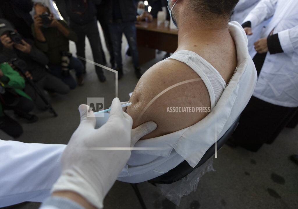 Nasser Nasser FILE - In this Wednesday, Feb. 3, 2021 file photo, a medic administers a Moderna COVID-19 vaccine to a fellow medic during a campaign to vaccinate front-line medical workers, at the health ministry, in the West Bank city of Bethlehem. In a new report released Thursday, Feb. 4, 2021, the International Monetary Fund said broad access to different coronavirus vaccines remains crucial for an economic recovery in the Mideast. (AP Photo/Nasser Nasser, File)