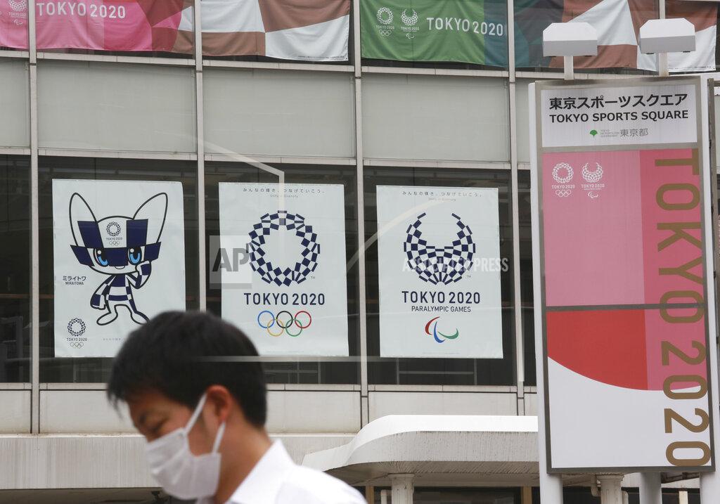 Koji Sasahara A man wearing a face mask to protect against the spread of the coronavirus walks by posters to promote the Tokyo Olympic Games in Tokyo Monday, June 7, 2021. (AP Photo/Koji Sasahara)