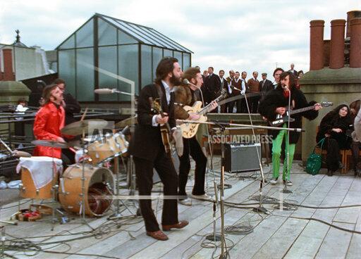 This image released by Disney+ shows, from left, Ringo Starr, Paul McCartney, John Lennon and George Harrison, with Yoko Ono, seated right, in a scene from the nearly 8-hour Peter Jackson-produced documentary “Get Back,” airing over three days starting Thanksgiving. (Disney+ via AP)