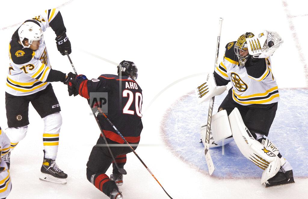 Chris Young Boston Bruins' goaltender Jaroslav Halak (41) makes a save as Bruins' Charlie McAvoy (73) battles with Carolina Hurricanes' Sebastian Aho (20) during the second period of a NHL Eastern Conference Stanley Cup playoff game in Toronto, on Saturday, Aug. 15, 2020. (Chris Young/The Canadian Press via AP)