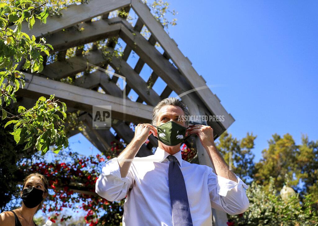 Shae Hammond California Gov. Gavin Newsom adjusts his face mask during a rally at St. Mary's Center in Oakland, Calif., Saturday, Sept. 11, 2021. The last day to vote in the recall election is Tuesday, Sept. 14. A majority of voters must mark "no" on the recall to keep Newsom in office. (Shae Hammond/Bay Area News Group via AP)