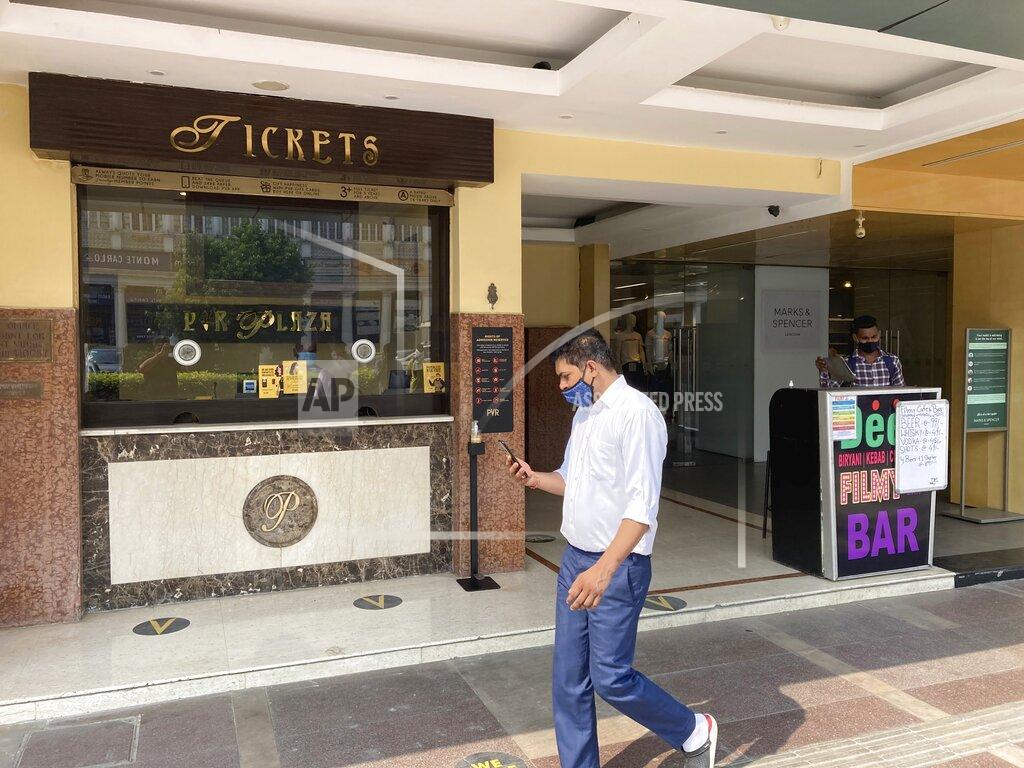 Shonal Ganguly A man wearing a face mask walks past the ticket counter of a movie hall in New Delhi, India, Thursday, oct. 15, 2020. After seven months of total blackout, cinemas reopened Thursday in several parts of India with few older titles on the marquee and shows limited to half the capacity. The reopening of movie theaters comes at a time when India’s confirmed coronavirus tally surpassed 7.3 million. (AP Photo/Shonal Ganguly)