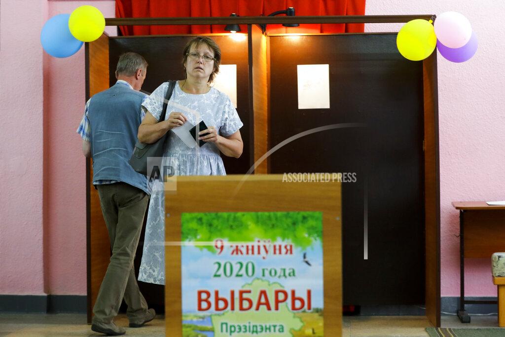 Sergei Grits A woman holds her ballot at a polling station during a early voting ahead of Sunday's election in Minsk, Belarus, Tuesday, Aug. 4, 2020. Belarus's authoritarian leader is vowing to maintain a close alliance with Russia despite the latest tensions as he seeks a sixth term in office amid a surge of opposition protests. President Alexander Lukashenko's comments in a state-of-the-nation address ahead of Sunday's election contrast with his diatribes against Russia last week. (AP Photo/Sergei Grits)