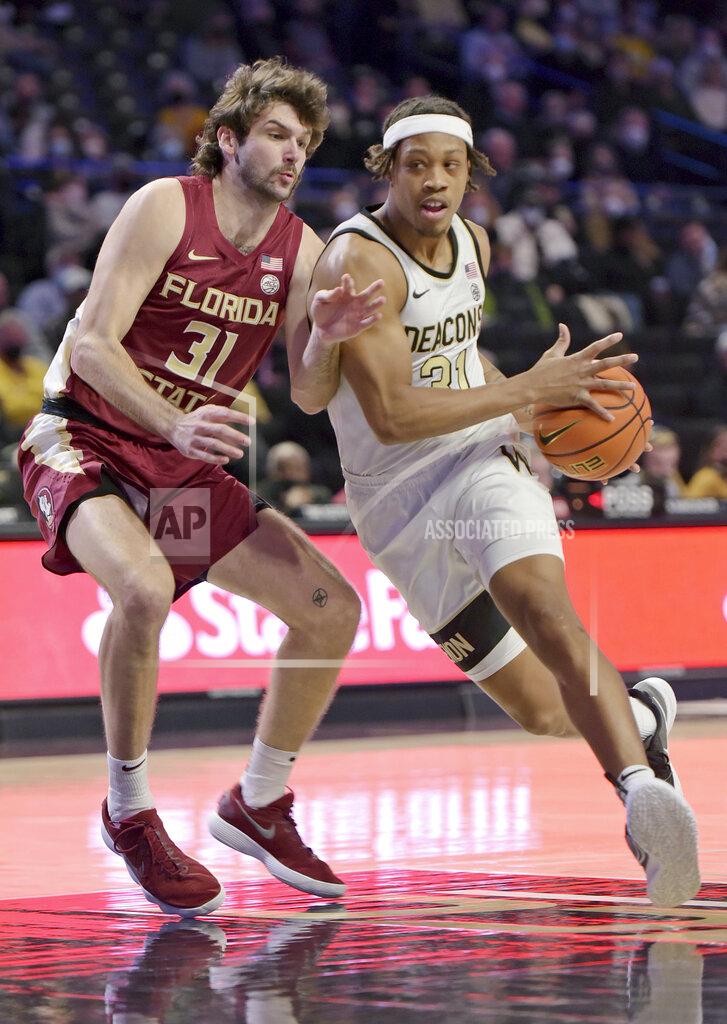 Walt Unks Wake Forest's Alondes Williams drives the lane against Florida State's Wyatt Wilkes in the first half of an NCAA college basketball game, Tuesday, Jan. 4, 2022 at Joel Coliseum in Winston-Salem, N.C. (Walt Unks/The Winston-Salem Journal via AP)