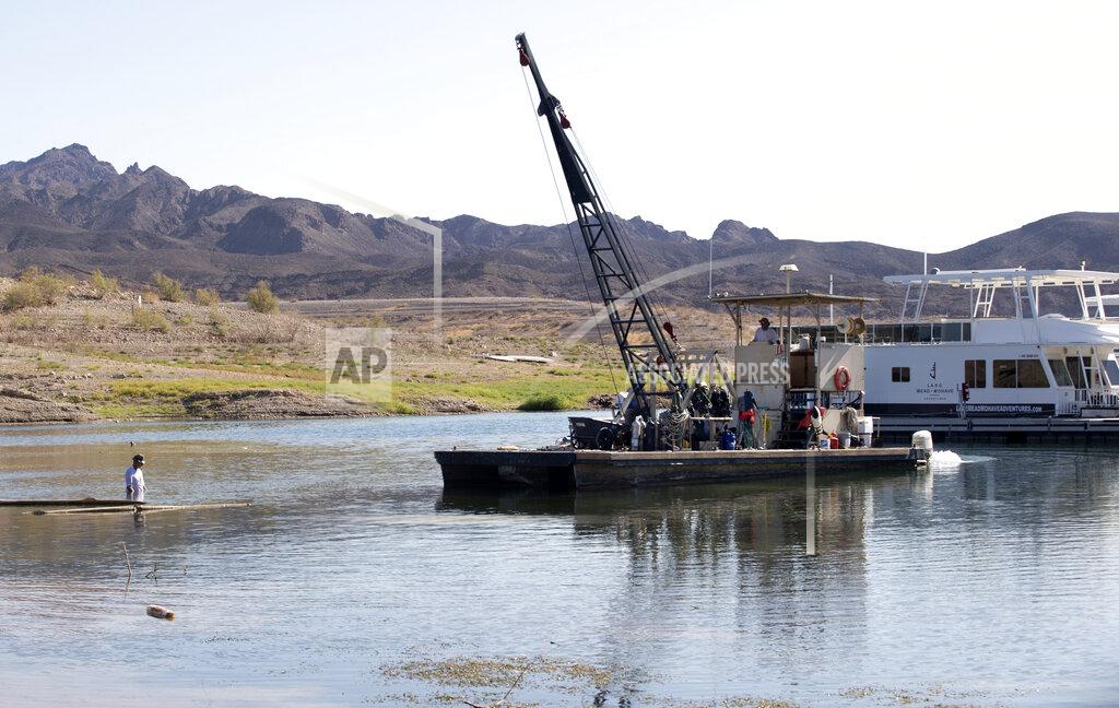 Steve Marcus A dock crew prepares to start work on moving the marina farther out into the lake due to falling water levels at the Callville Bay Marina in the Lake Mead National Recreation Area Tuesday, Sept. 14, 2021 in Las Vegas. Some businesses that depend on the Colorado River caught a wave of customers after coronavirus pandemic closures closed schools and offices. But boat rental and recreation company chief Chad Taylor says that receding water levels at Lake Mead, the river’s drought-stricken reservoir, have him constantly moving docks farther into Callville Bay. (Steve Marcus /Las Vegas Sun via AP)