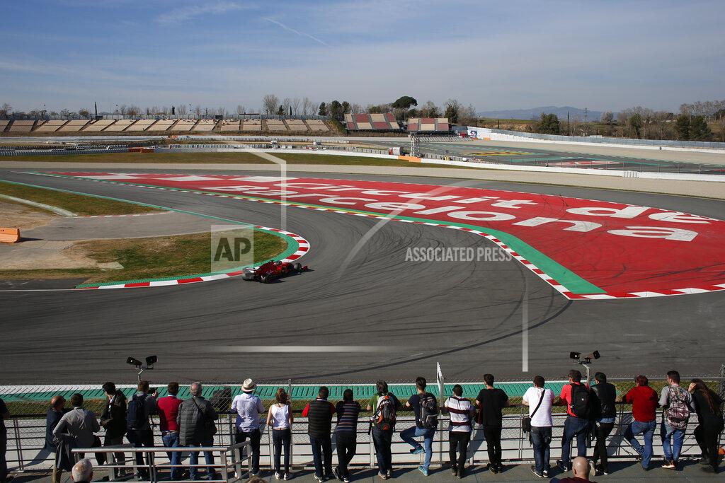 Joan Monfort Motor racing fans watch as a Ferrari takes a curve during a Formula One pre-season testing session at the Catalunya racetrack in Montmelo, outside Barcelona, Spain, Tuesday, Feb. 26, 2019. (AP Photo/Joan Monfort)