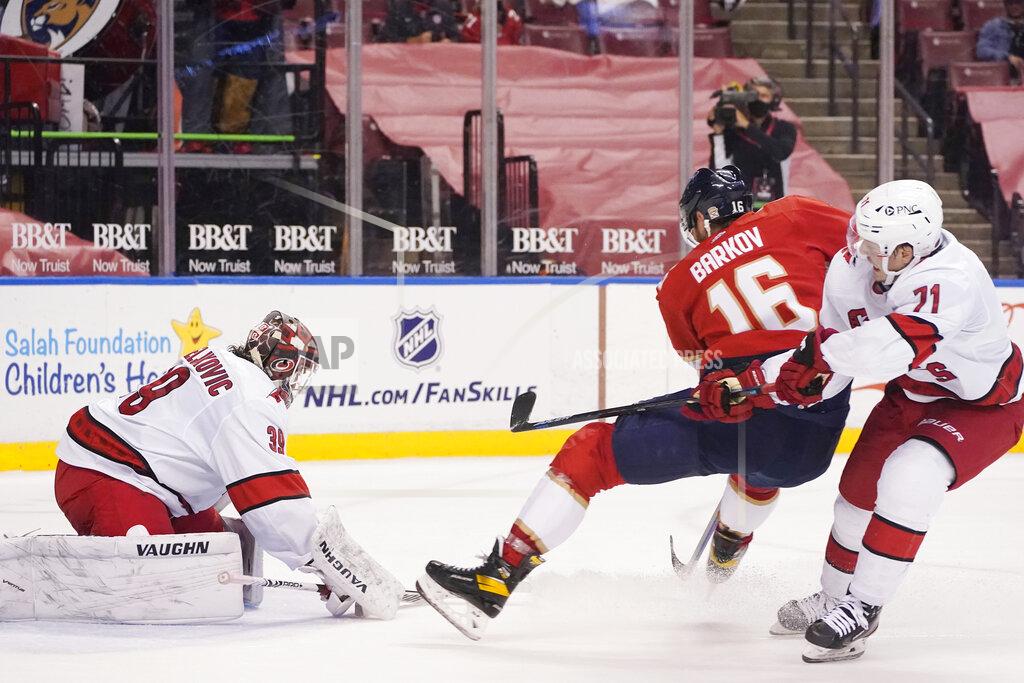 Wilfredo Lee Florida Panthers center Aleksander Barkov (16) attempts a shot at Carolina Hurricanes goaltender Alex Nedeljkovic (39) and right wing Jesper Fast (71) during the second period of an NHL hockey game, Monday, March 1, 2021, in Sunrise, Fla. (AP Photo/Wilfredo Lee)