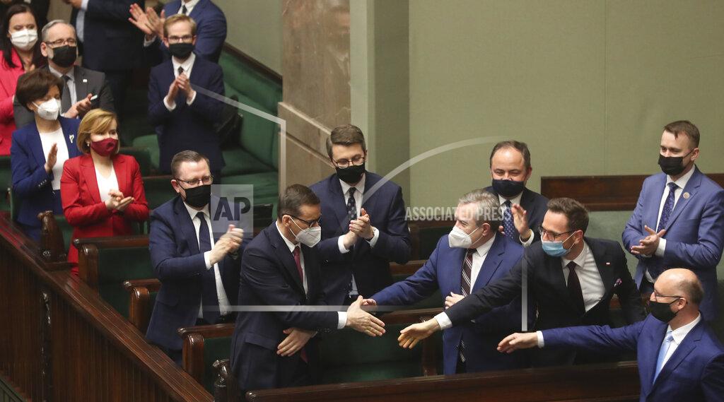 Czarek Sokolowski Poland's members of government with Prime Minister Mateusz Morawiecki, center, react after voting – some in parliament, some remotely – in Warsaw, Poland, on Tuesday, May 4, 2021. Polish lawmakers have voted to approve the nation’s spending plan for the 58 billion euros ($70 billion) it expects to receive from the European Union’s pandemic recovery plan. (AP Photo/Czarek Sokolowski)