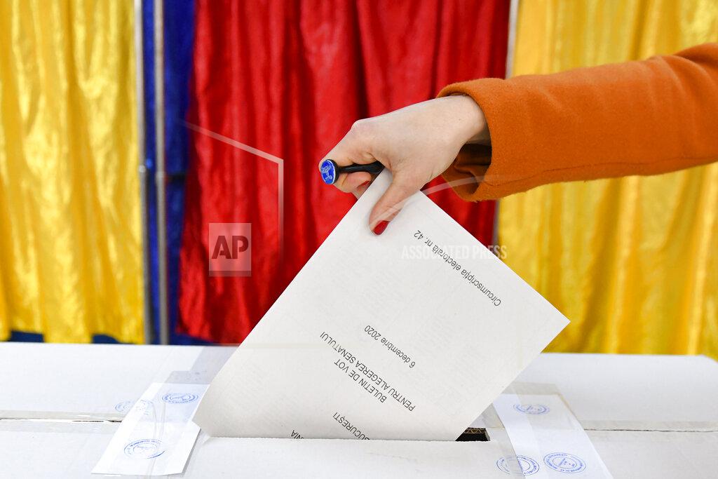 Andreea Alexandru A woman casts her vote in Bucharest, Romania, Sunday, Dec. 6, 2020. Voting started in Romania's legislative election expected to restore some measure of stability after five years of political and social turbulence with more than 18 million Romanians registered to vote for a new legislative body. (AP Photo/Andreea Alexandru)
