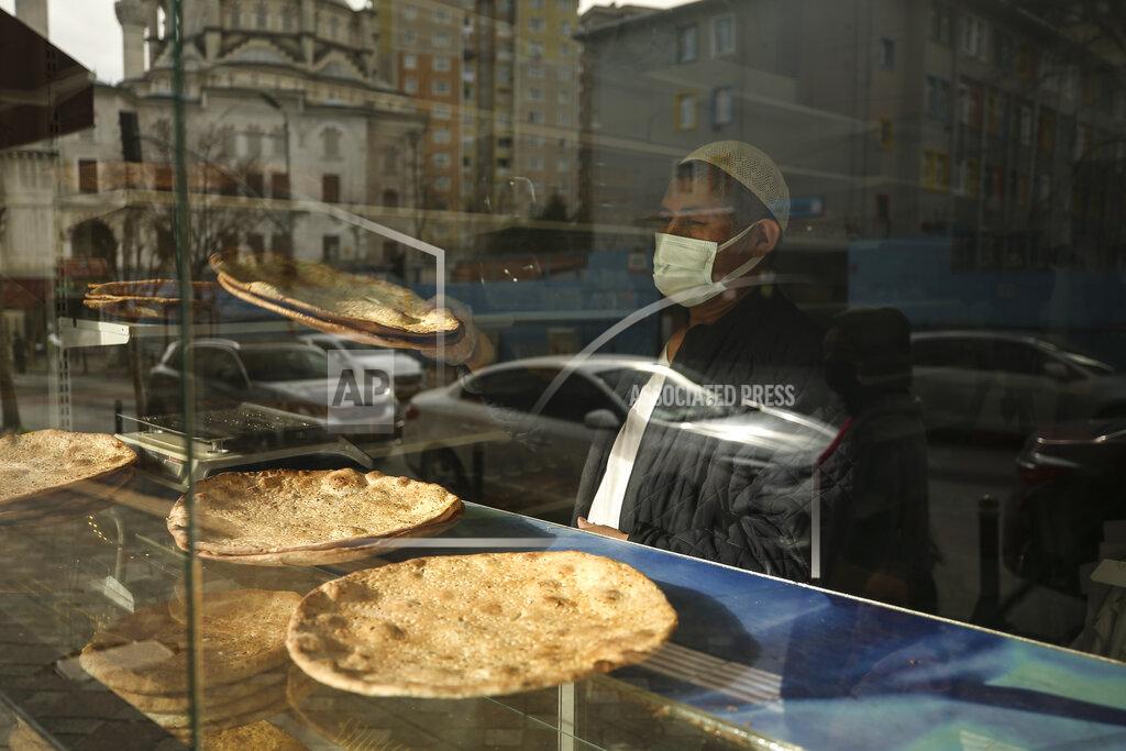 Emrah Gurel Muhammed Emin, a member of the Uighur community living in Turkey, looks outside in his bakery in Istanbul, Tuesday, Feb. 2, 2021. Because of shared cultural ties, Turkey has long been a safe haven for the Uighurs, a Turkic group native to China's far west Xinjiang region. Opposition legislators in Turkey are accusing Ankara's leaders of secretly selling out Uighurs to China in exchange for coronavirus vaccines. (AP Photo/Emrah Gurel)