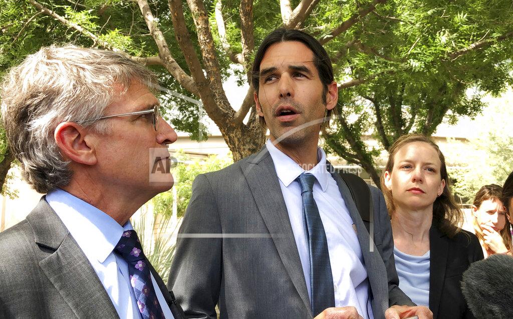 FILE - In this June 11, 2019, file photo, Scott Warren, center, speaks outside federal court, in Tucson, Ariz., after a mistrial was declared in the federal case against him. Warren is scheduled to testify Tuesday, Nov. 19, 2019, in the second criminal case against his actions as a member of a humanitarian aid group. Prosecutors say Warren was arrested in early 2018 after harboring two men who sneaked across the U.S.-Mexico border. (AP Photo/Astrid Galvan, File)