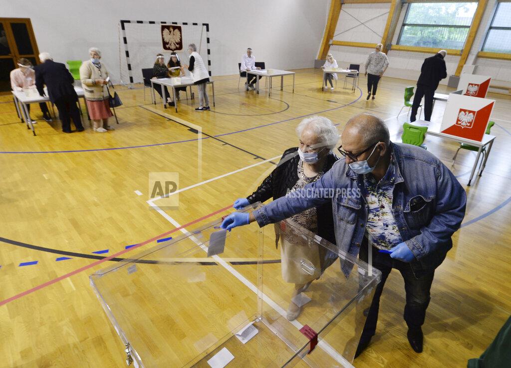 Czarek Sokolowski Voters cast their ballots shortly after polling stations open in Poland's tight presidential election runoff between conservative incumbent President Andrzej Duda and liberal Warsaw Mayor Rafal Trzaskowski in Lomianki, near Warsaw, Poland, on Sunday, July 12, 2020. Latest polls showed that the race may be decided by a very small margin. (AP Photo/Czarek Sokolowski)