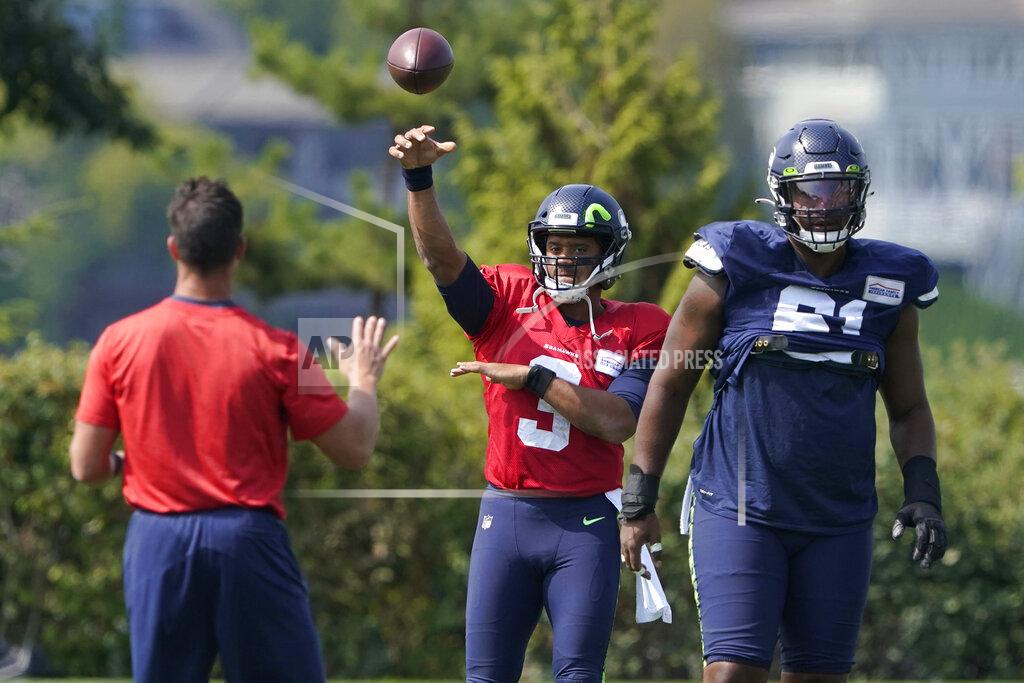Ted S. Warren Seattle Seahawks quarterback Russell Wilson (3) passes after taking a snap from center Kyle Fuller, right, during NFL football practice Wednesday, Aug. 25, 2021, in Renton, Wash. (AP Photo/Ted S. Warren)