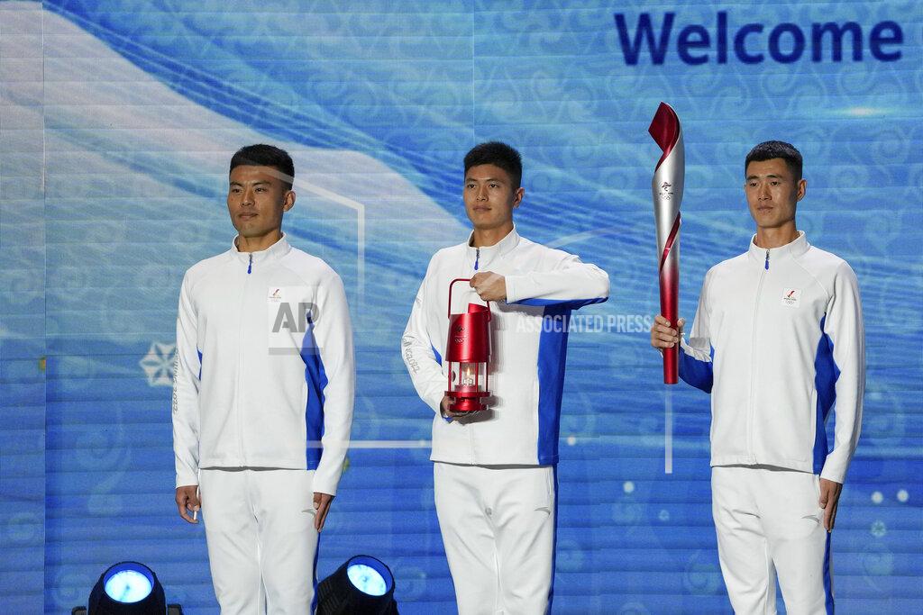 Andy Wong Volunteers hold the Olympic torch and the frame on stage during a welcome ceremony for the Frame of Olympic Winter Games Beijing 2022, held at the Olympic Tower in Beijing, Wednesday, Oct. 20, 2021. A welcome ceremony for the Olympic flame was held in Beijing on Wednesday morning after it arrived at the Chinese capital from Greece. While the flame will be put on display over the next few months, organizers said a three-day torch relay is scheduled starting February 2nd with around 1200 torchbearers in Beijing, Yanqing and Zhangjiakou. (AP Photo/Andy Wong)