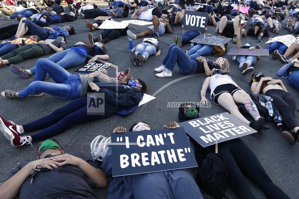 Rich Pedroncelli Protesters lie silent for 8 minutes and 46 seconds, Friday, June 5, 2020, during a demonstration to honor George Floyd, near the home of Sacramento Mayor Darrell Steinberg in Sacramento, Calif. Floyd, a black man, died after being restrained by Minneapolis police officers on May 25. (AP Photo/Rich Pedroncelli)