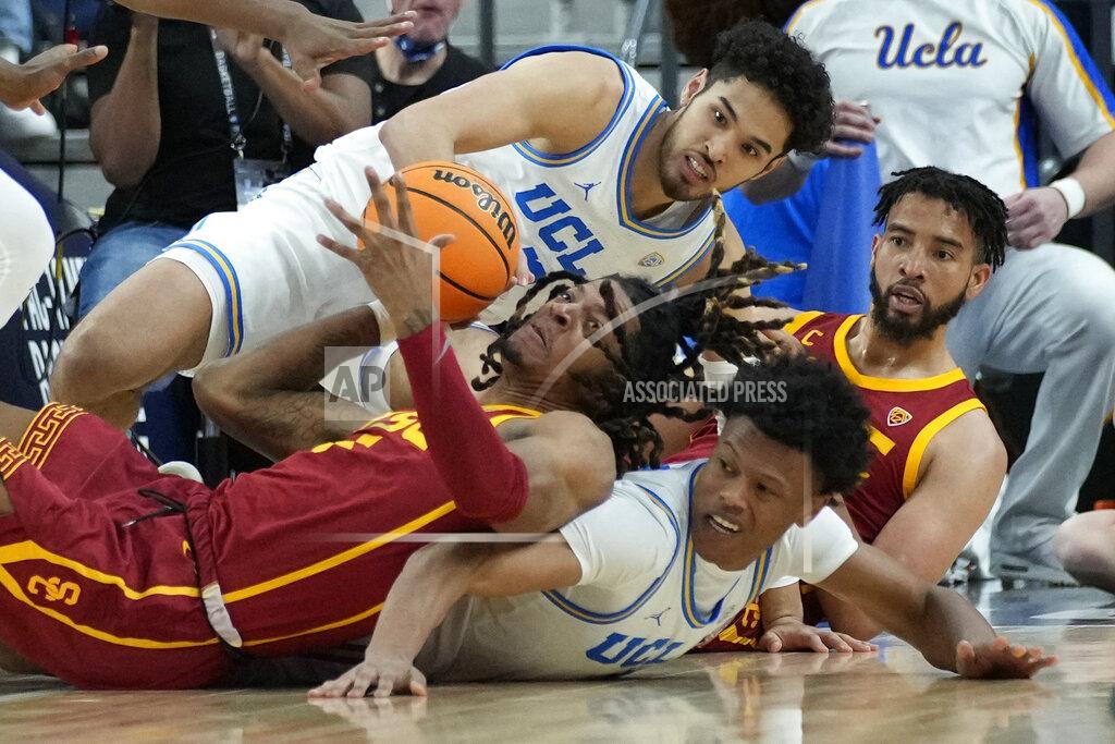 John Locher Southern California's Isaiah White, left, and UCLA's Jaylen Clark scramble for the ball during the first half of an NCAA college basketball game in the semifinal round of the Pac-12 tournament Friday, March 11, 2022, in Las Vegas. (AP Photo/John Locher)