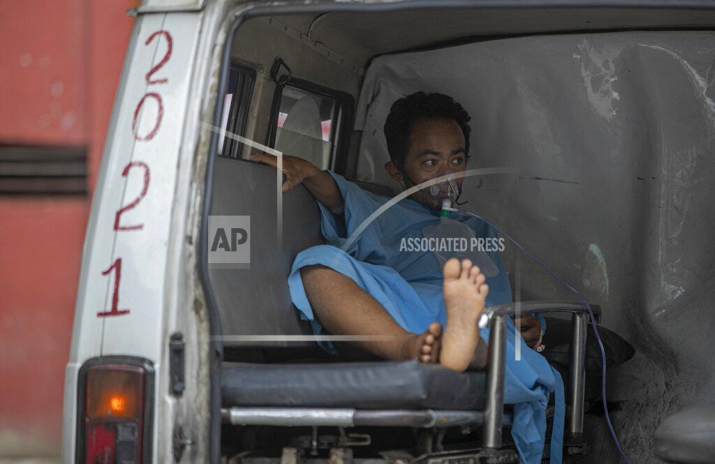 Niranjan Shrestha A COVID-19 patient receives oxygen in an ambulance outside an emergency ward of a hospital as he waits for an intensive care bed to be allotted in Kathmandu, Nepal, Friday, May 7, 2021. Across the border from a devastating surge in India, doctors in Nepal warned Friday of a major crisis as daily coronavirus cases hit a record and hospitals were running out of beds and oxygen. (AP Photo/Niranjan Shrestha)