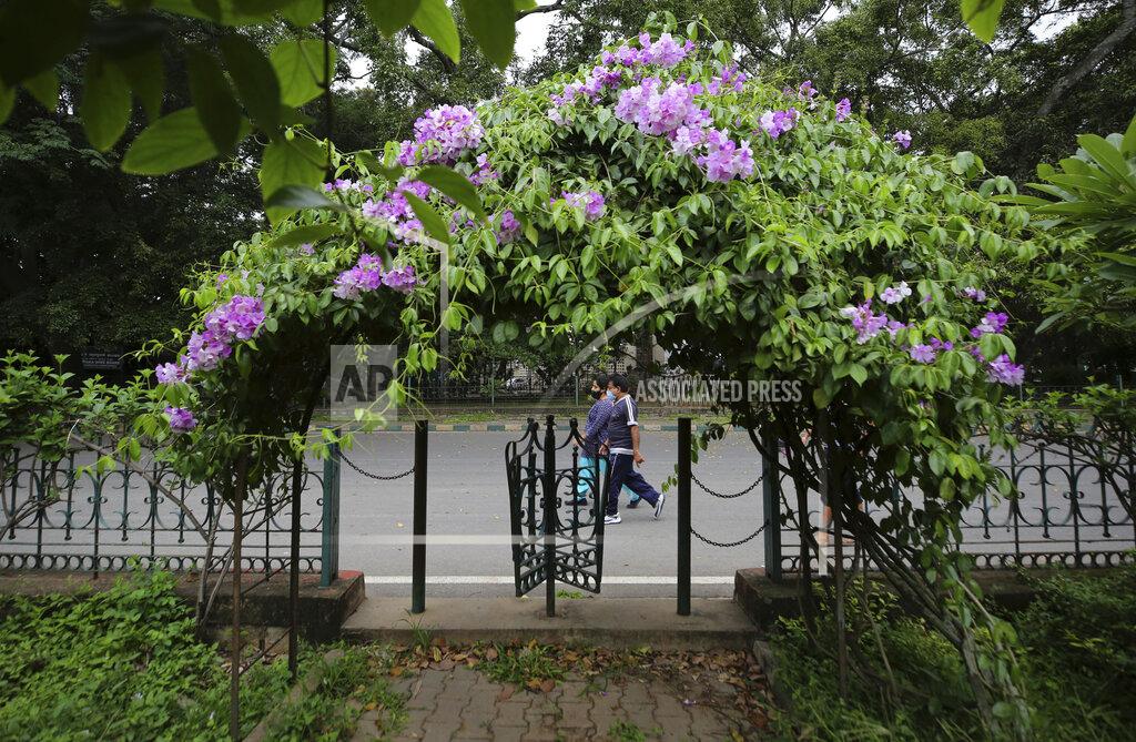 Aijaz Rahi An Indian couple wearing face masks as a precaution against the coronavirus walk outside a public park in Bengaluru, India, Wednesday, June 16, 2021. Public parks and other open spaces in the city were thrown open to public since Monday after partially easing restrictions following a drop in new infections. Authorities are still warning people to wear face masks and maintain a safe distance. (AP Photo/Aijaz Rahi)