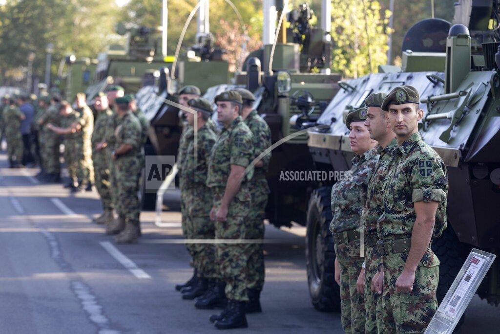 Marko Drobnjakovic Serbian army soldiers stand to attention in front of armored personnel carriers on display as part of a newly established "Serbian Unity Day" holiday in Belgrade, Serbia, Wednesday, Sept. 15, 2021. Serbia has kicked off a new holiday celebrating national unity with a display of military power, triggering unease among its neighbors. The new holiday comes decades after similar calls for unity led to the bloody wars in the Balkans in the 1990s. Serbs in the region were told to display thousands of red, blue and white national flags wherever they live in the region or the world to mark “The Day of Serb Unity, Freedom and the National Flag.” Serbian officials are calling for the creation of a “Serb World,” or political unification of an estimated 1.3 million Serbs who live in Bosnia, Montenegro, Kosovo and Croatia with Serbia. (AP Photo/Marko Drobnjakovic)