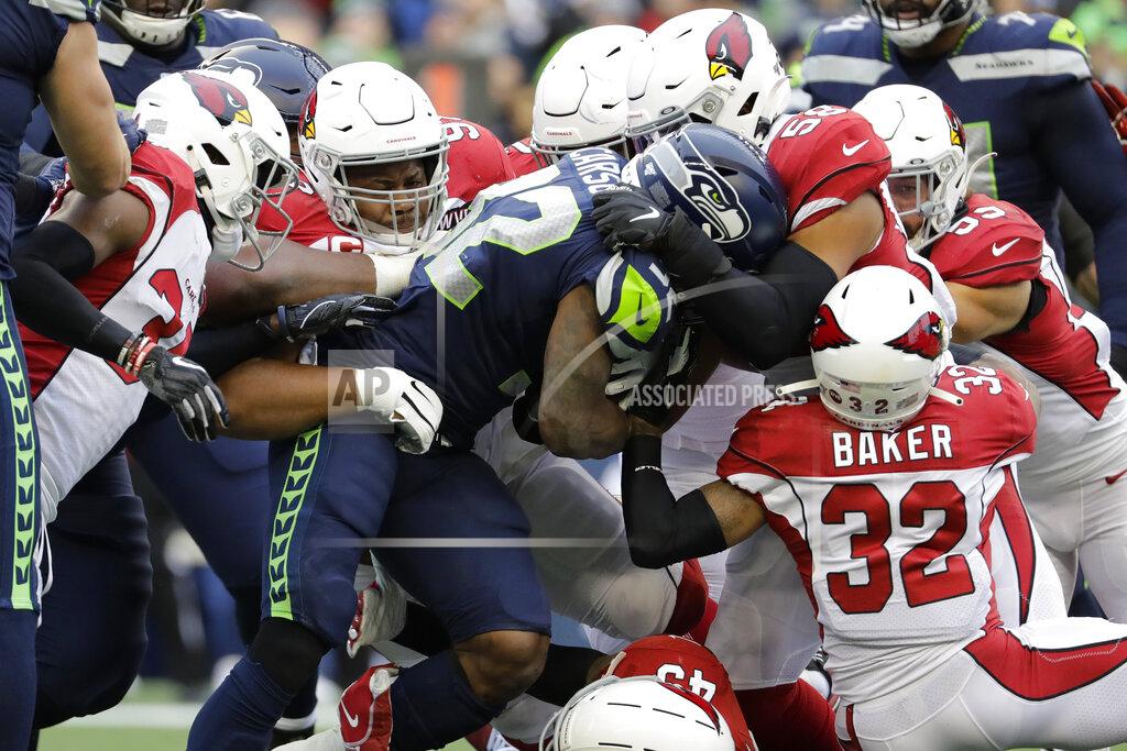 Lindsey Wasson Seattle Seahawks running back Chris Carson (32) is tackled by Arizona Cardinals strong safety Budda Baker (32) and middle linebacker Jordan Hicks (58) during the first half of an NFL football game, Sunday, Dec. 22, 2019, in Seattle. (AP Photo/Lindsey Wasson)