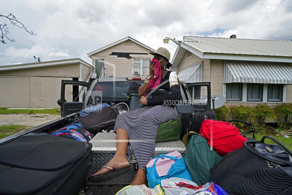 Gerald Herbert Rakisha Murray cries in relief as she arrives to see her mother's home largely undamaged, after she returned from evacuation with her mother and other family in Lake Charles, La., in the aftermath of Hurricane Laura, Sunday, Aug. 30, 2020. (AP Photo/Gerald Herbert)