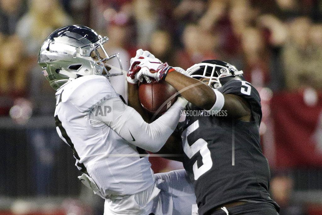 Young Kwak Washington State wide receiver Travell Harris (5) catches a pass while defended by Oregon safety Jevon Holland during the second half of an NCAA college football game in Pullman, Wash., Saturday, Oct. 20, 2018. Washington State won 34-20. (AP Photo/Young Kwak)