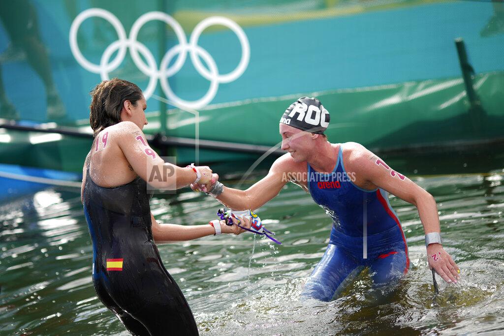 David Goldman Paula Ruiz Bravo, of Spain, left, helps up Anastasiia Kirpichnikova, of the Russian Olympic Committee, after they finished in the women's marathon swimming event at the 2020 Summer Olympics, Wednesday, Aug. 4, 2021, in Tokyo. (AP Photo/David Goldman)