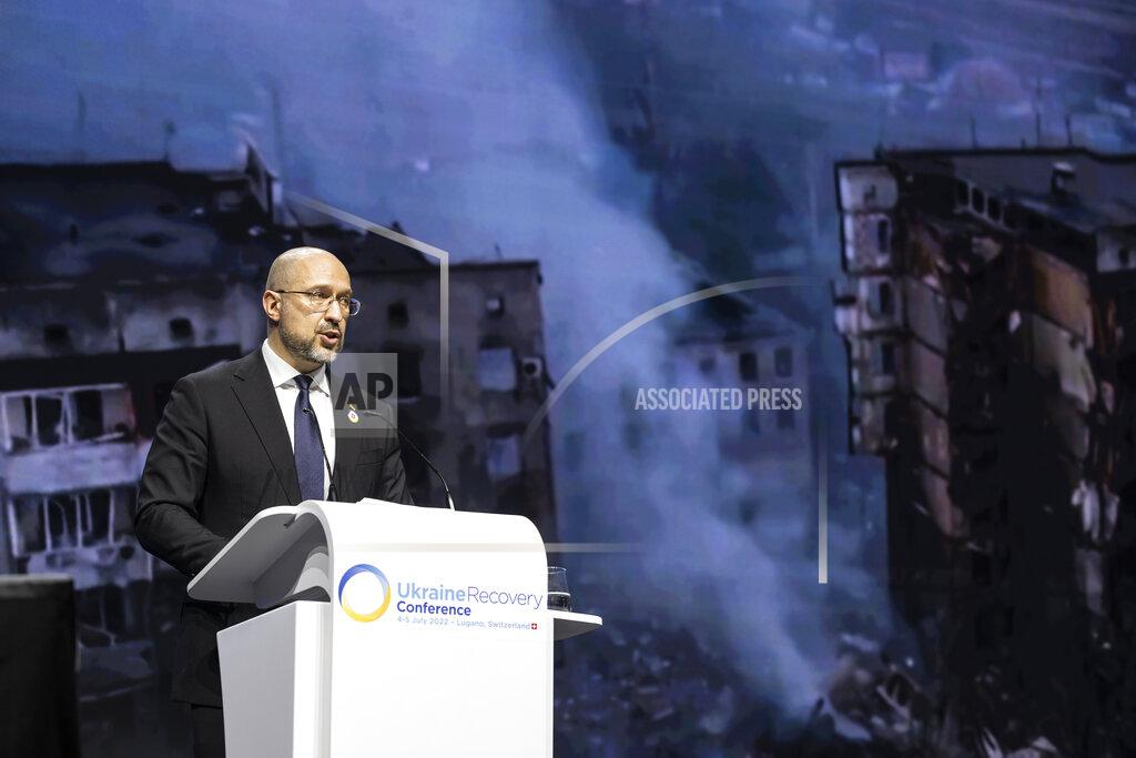 Alessandro Della Valle Ukrainian Prime Minister Denys Shmyhal speaks with footage from the war projected on screen during a plenary session at the Ukraine Recovery Conference URC, Monday, July 4, 2022 in Lugano, Switzerland. The URC is organised to initiate the political process for the recovery of Ukraine after the attack of Russia to its territory. (Alessandro della Valle/Keystone via AP)